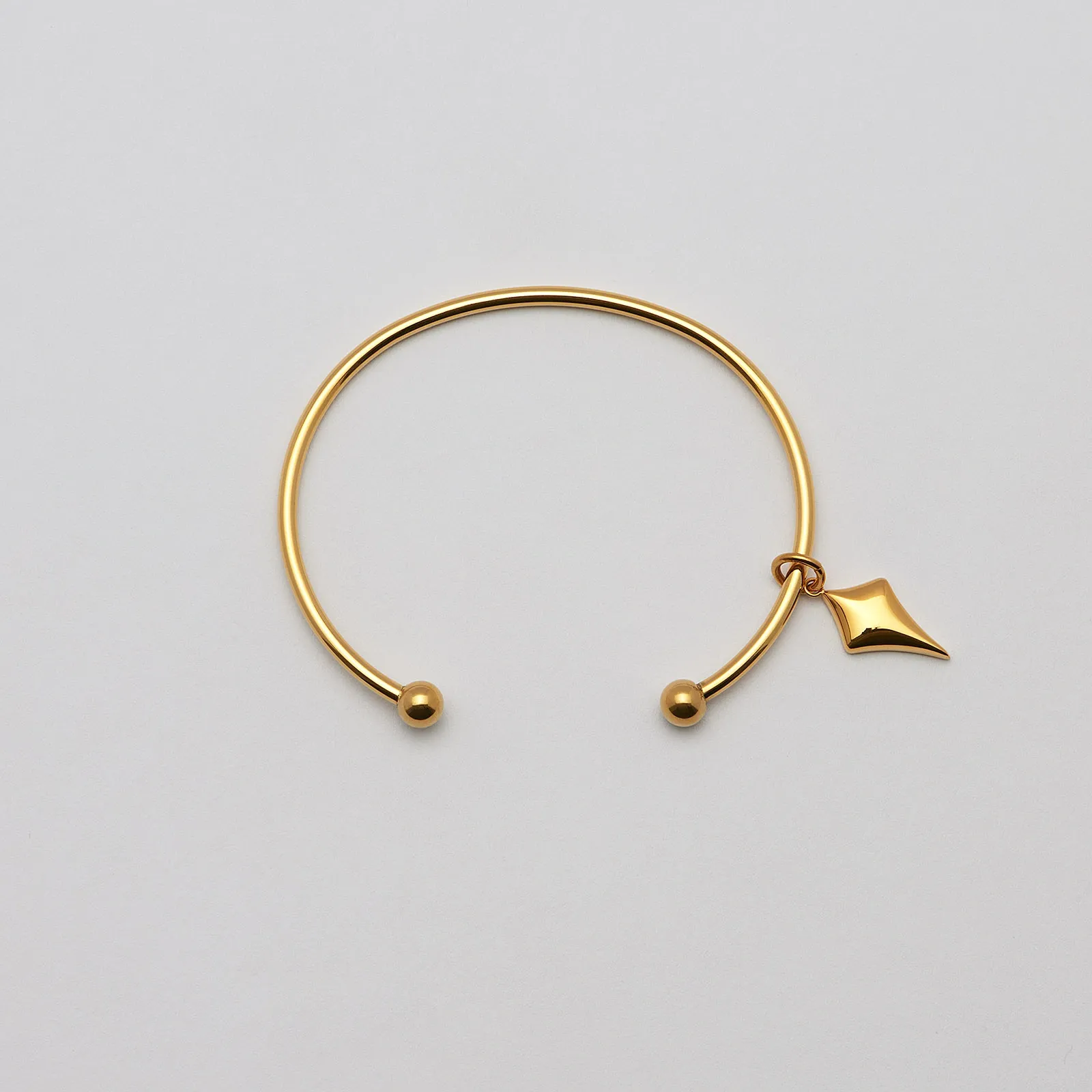 Armband i guldpläterat stål, bangle pil- 66,5 mm